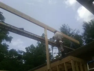 Carpenter setting a ridge beam over a new addition frame — Ice Dam Removal by Roofing Brothers in Rockfield