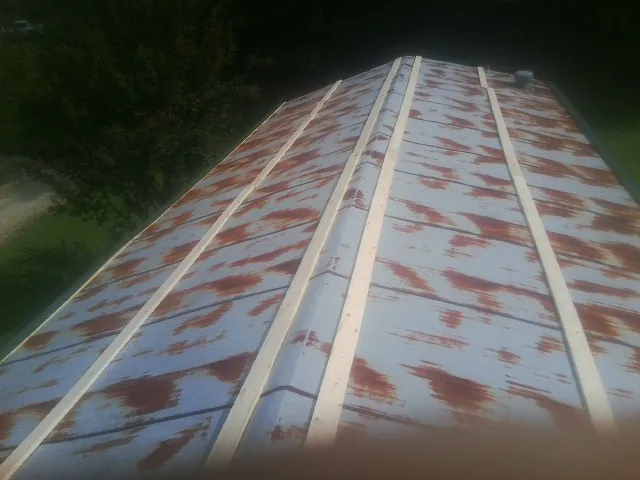 Rusted metal roof panels with new wood purlins before replacement — Storm Damage Roof Repair in Rockfield by Roofing Brothers