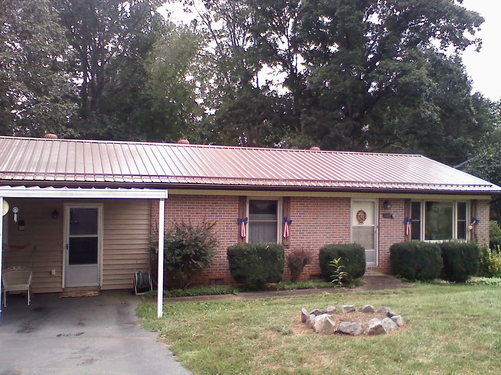 Bronze metal roof and carport on a brick ranch home — Roof Repair work by our crew in Rockfield
